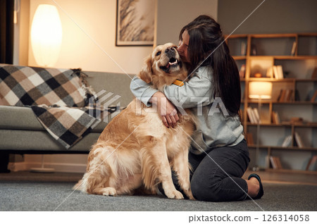Kissing the dog. Woman is with golden retriever at home 126314058