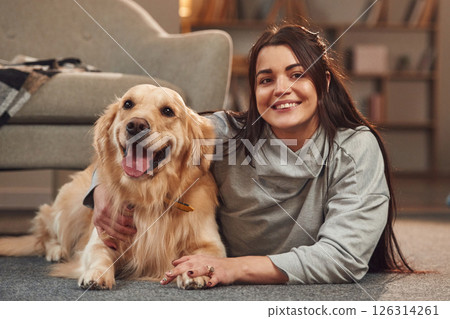 Positive emotions. Playing together. Woman is with golden retriever dog at home 126314261