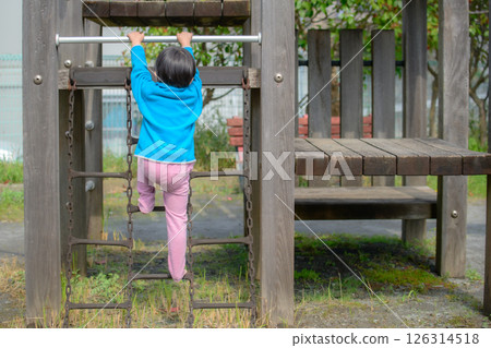 一名幼兒園女孩在公園的遊樂場玩耍 一名幼兒園女孩在公園的遊樂場玩耍 126314518
