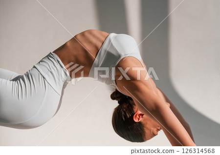 Young caucasian woman with slim body shape is indoors in the studio. Fitness exercises Young caucasian woman with slim body shape is indoors in the studio. Fitness exercises 126314568