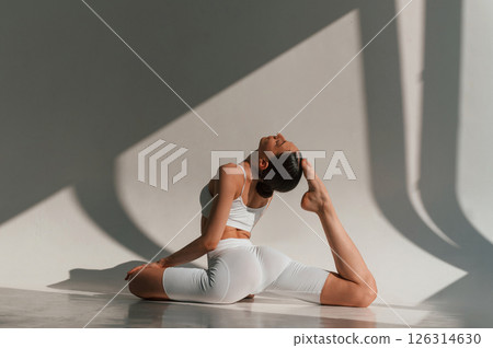 Nice flexible body. Young caucasian woman is indoors in the studio 126314630