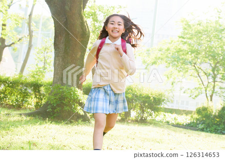 Elementary school girl running with school bag 126314653