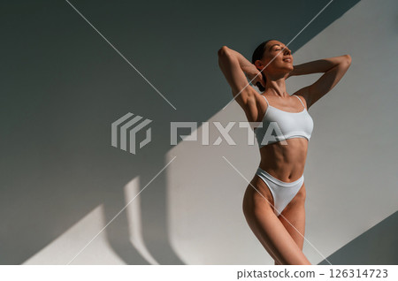 Slim body shape. Young caucasian woman is indoors in the studio 126314723
