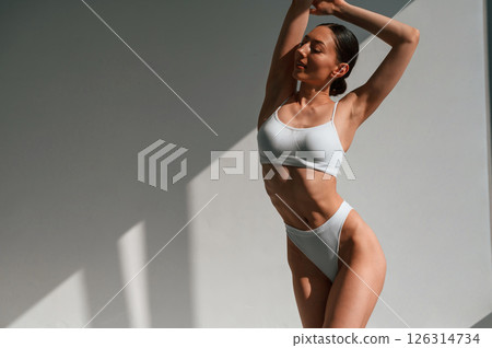 Woman with slim body shape is indoors in the studio. Model is posing Woman with slim body shape is indoors in the studio. Model is posing 126314734