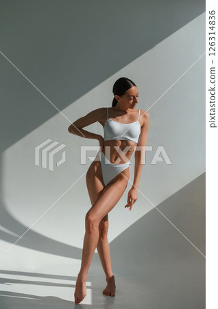 Tall figure. Young caucasian woman with slim body shape is indoors in the studio Tall figure. Young caucasian woman with slim body shape is indoors in the studio 126314836