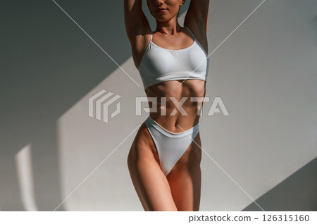 In the studio with beautiful sunlight. Young caucasian woman with slim body shape In the studio with beautiful sunlight. Young caucasian woman with slim body shape 126315160