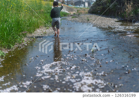 A boy playing in the river in the spring sunshine 126316199