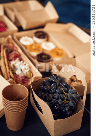 Close up view of blueberries, sweet desserts and meat that is on the table in the paper eco boxes 126316721
