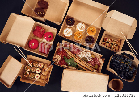 Close up view of table with food on it. Meat, vegetables, sushi, French fries, burger, mushrooms Close up view of table with food on it. Meat, vegetables, sushi, French fries, burger, mushrooms 126316723