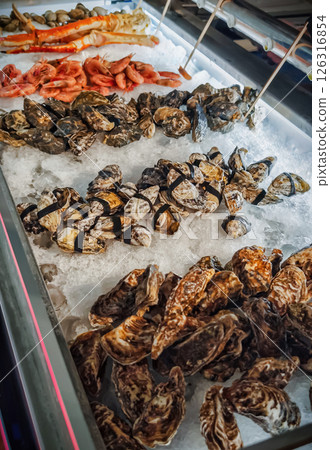 Seafood display with fresh oysters, shrimp, and crab at a market during the day 126316854