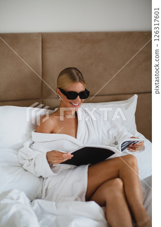 Close-up portrait of seductive young bride in hotel room wrapped in white blanket 126317601