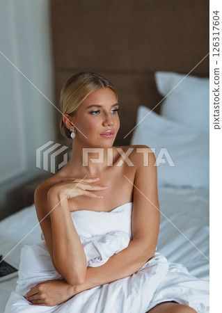 Close-up portrait of seductive young bride in hotel room wrapped in white blanket Close-up portrait of seductive young bride in hotel room wrapped in white blanket 126317604