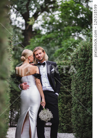 Stylish young beautiful newlywed couple posing at wedding in beautiful green park Stylish young beautiful newlywed couple posing at wedding in beautiful green park 126318599