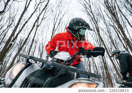 Two people are riding ATV in the winter forest 126318615