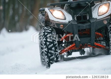 Snow, trees, adventure. Man is riding ATV outdoors in the winter forest 126318619