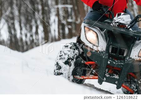 Man is riding ATV outdoors in the winter forest 126318622