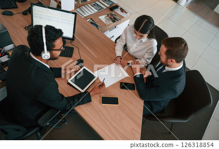 Two men and woman are sitting in the office and working 126318854