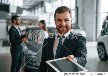 Using graphic tablet. Three people are working together in the car showroom 126318874