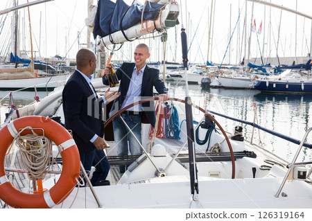 Men in suits relaxing on a yacht in the seaport Men in suits relaxing on a yacht in the seaport 126319164