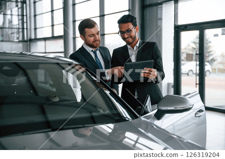 Man is consulting the customer in the car showroom 126319204