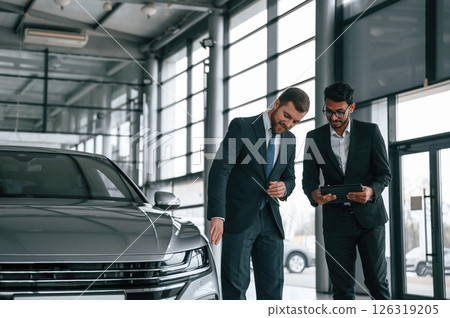 Man is consulting the customer in the car showroom 126319205