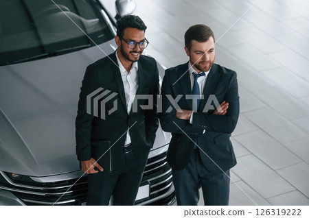 View from the top. Two businessmen are working together in the car showroom View from the top. Two businessmen are working together in the car showroom 126319222