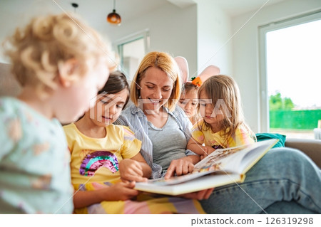 Enjoying story time together in a cozy living room Enjoying story time together in a cozy living room 126319298