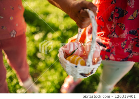 Children joyfully hunt for colorful eggs on a sunny day 126319401