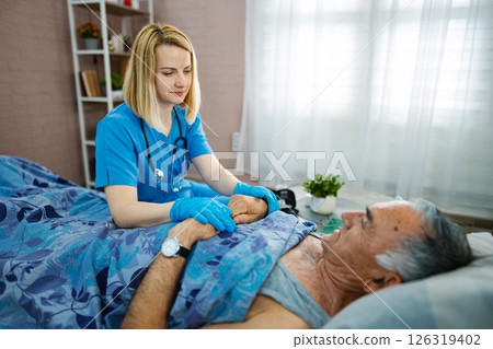 Nurse providing compassionate care to elderly patient 126319402