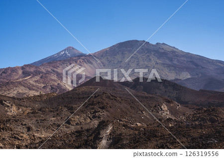 Winter view on colorful volcano Pico del Teide with snow spots from hiking trail Samara. Mountains and lava fields against blue sky. El Teide National Park, Tenerife, Canary Islands, Spain 126319556