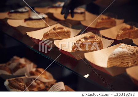 Close up view of man's hands in gloves that taking delicious desserts Close up view of man's hands in gloves that taking delicious desserts 126319788
