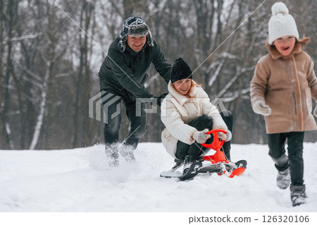 Sled ride. Mother and father is with daughter have walk outdoors at the winter season 126320106
