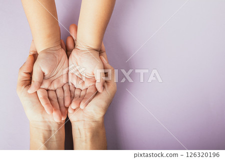Family day concept, Top view of parents and kid holding empty hands together on a color background. Celebrating togetherness. Family day concept, Top view of parents and kid holding empty hands together on a color background. Celebrating togetherness. 126320196