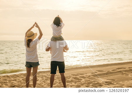 Happy family in holiday. Father, Mother and kids having fun together shoulder ride on summer beach, Parents carrying children on neck at beach, family is enjoying their summer in sunset time Happy family in holiday. Father, Mother and kids having fun together shoulder ride on summer beach, Parents carrying children on neck at beach, family is enjoying their summer in sunset time 126320197