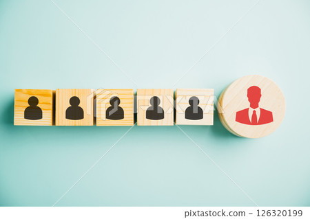 Red manager icon prominently standing out from set of staff employee icons printed on wooden block. concept of different thinking, talent development, and role of leadership in corporate environment. 126320199