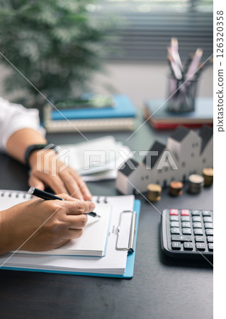 Finance bank tax expense accounting budget money businessman home for Business expense analysis saving use Financial calculate accountant close up calculator with graph chart hand write office desk 126320358