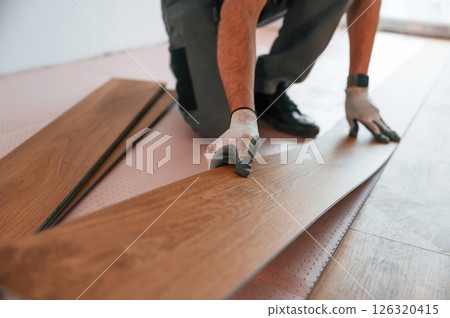 Close up view. Man is installing new laminated wooden floor 126320415