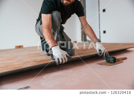 Hand work. Man is installing new laminated wooden floor Hand work. Man is installing new laminated wooden floor 126320418