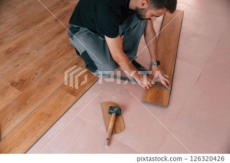 Top view. Man is installing new laminated wooden floor 126320426