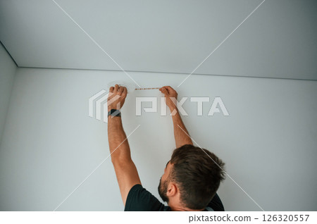 Man is working with lighting equipment indoors at domestic room 126320557