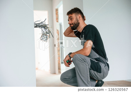 Electrician is working with wires indoors in the room 126320567