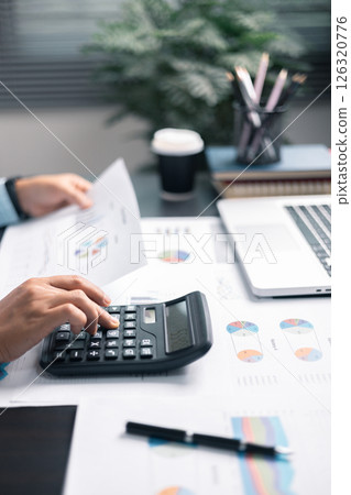 Finance bank tax expense accounting budget money businessman hand use calculator Financial calculate accountant close up calculator with graph chart write office desk Business expense analysis saving 126320776