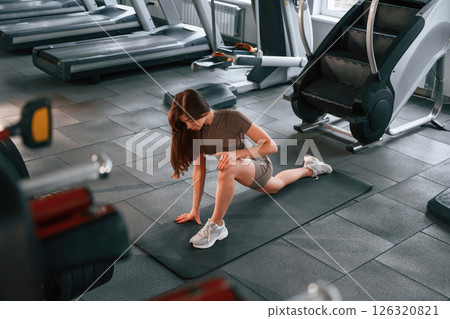 Doing squats. Beautiful woman with sport body type is in the gym Doing squats. Beautiful woman with sport body type is in the gym 126320821