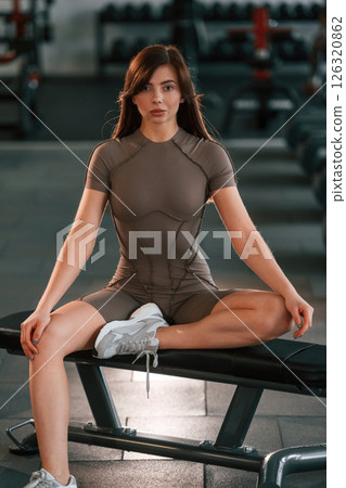Sitting and having a break. Beautiful woman with sport body type is in the gym 126320862