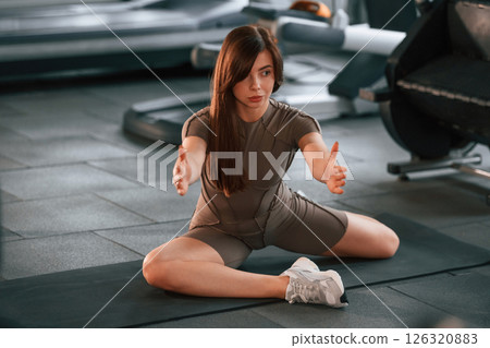 Stretching exercises. Beautiful woman with sport body type is in the gym Stretching exercises. Beautiful woman with sport body type is in the gym 126320883