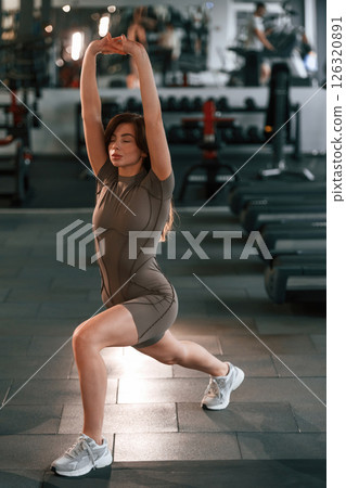 Legs exercises. Beautiful woman with sport body type is in the gym Legs exercises. Beautiful woman with sport body type is in the gym 126320891