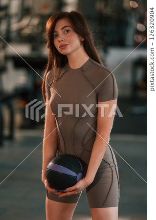 Portrait of beautiful woman with sport body type that is in the gym. Holding fitness ball 126320904