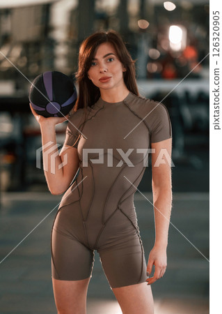 Portrait of beautiful woman with sport body type that is in the gym. Holding fitness ball 126320905