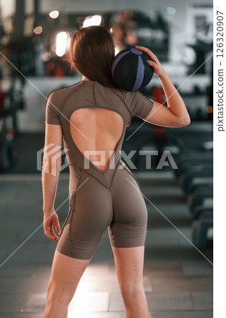 Rear view. Beautiful woman with sport body type is in the gym Rear view. Beautiful woman with sport body type is in the gym 126320907