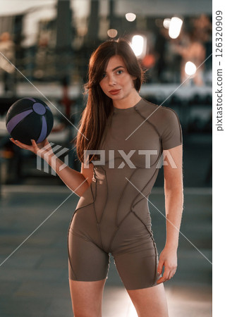Portrait of beautiful woman with sport body type that is in the gym. Holding fitness ball 126320909